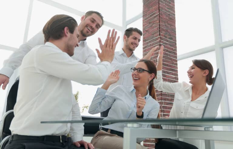 Equipo de agentes de Keller Williams España en una sesión de formación celebrando el éxito colaborativo gracias a los sistemas y modelos de crecimiento de KW