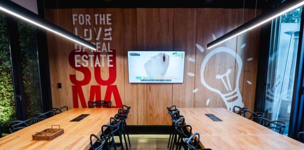 Oficina moderna de franquicia inmobiliaria Keller Williams con agentes colaborando en un espacio coworking