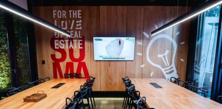 Oficina moderna de franquicia inmobiliaria Keller Williams con agentes colaborando en un espacio coworking