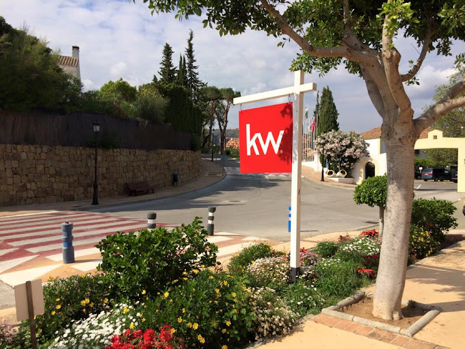 Cartel de la franquicia Keller Williams en una zona residencial en España, demostrando la presencia de marca necesaria para un negocio inmobiliario de éxito.